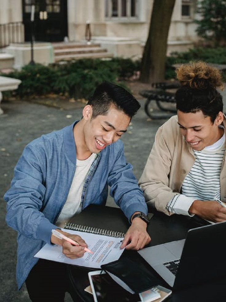 Students working together on their studies outdoors on campus